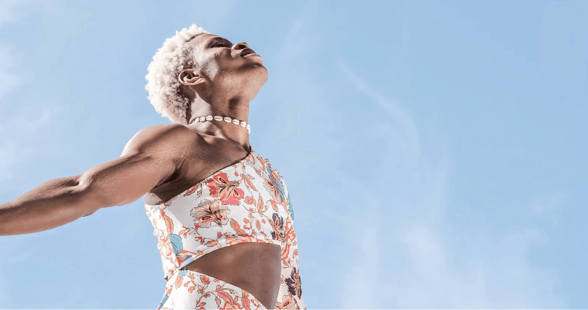 Person beneath open sky — grounded, radiant wellness